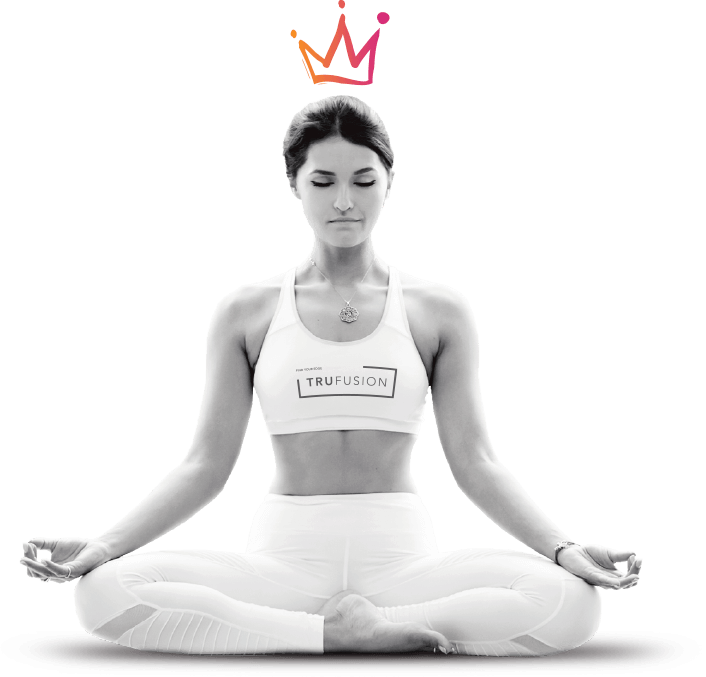 A woman wearing TruFusion branded workout clothing, in a yoga pose with a crown icon above her head